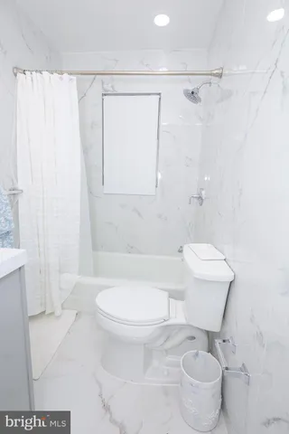 a view of a room with a white wall and a window