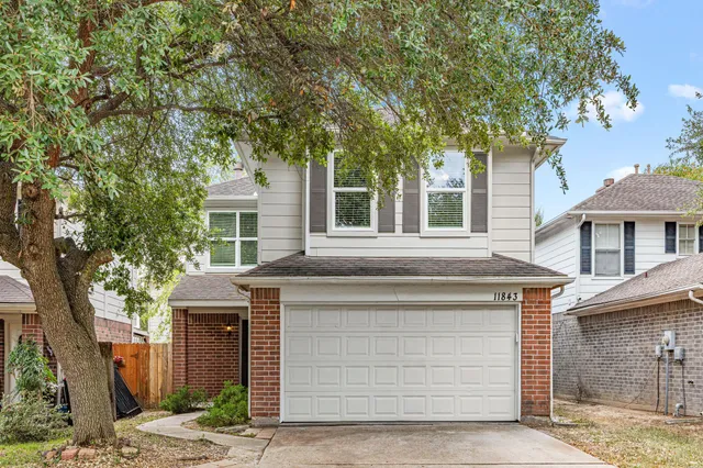 a front view of a house with a tree