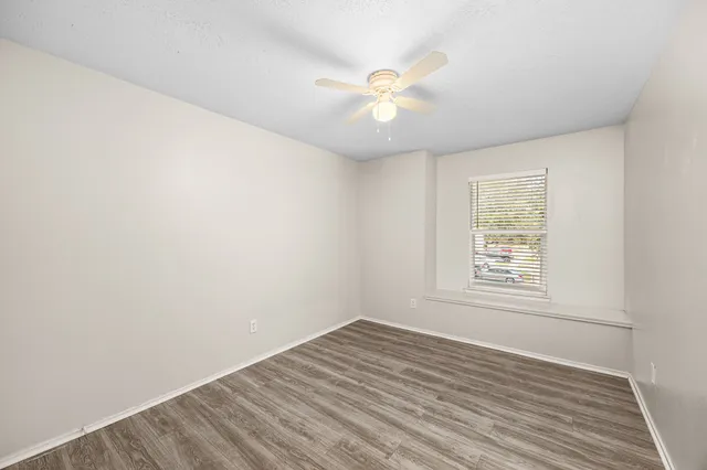 a bathroom with a granite countertop bathtub shower sink vanity and toilet