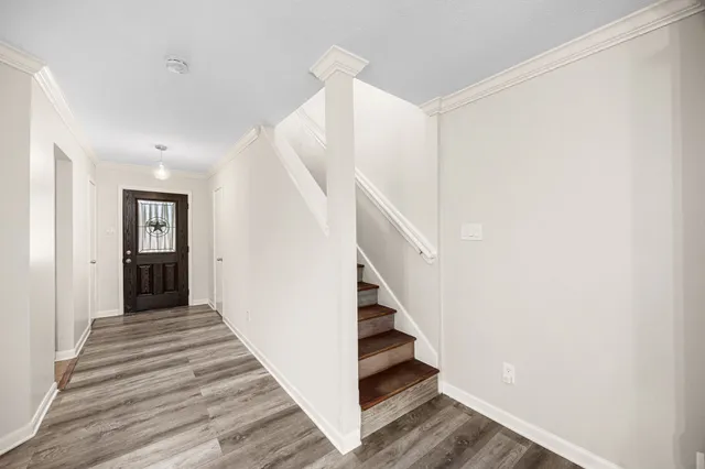 a view of a hallway with wooden floor and entryway