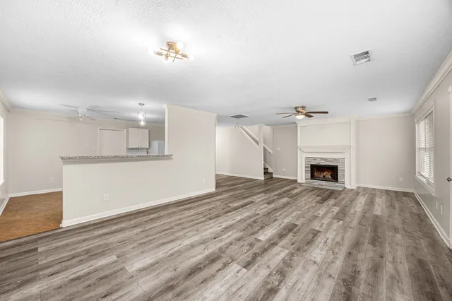a view of empty room with wooden floor and fireplace