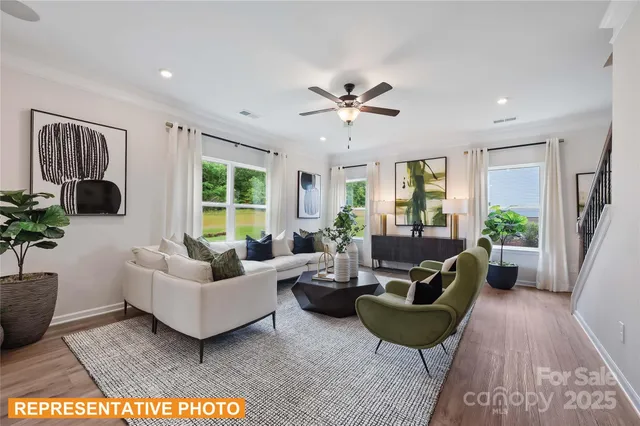 a living room with furniture a large window and a rug