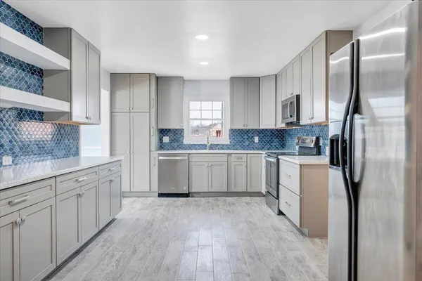a kitchen with white cabinets sink and refrigerator