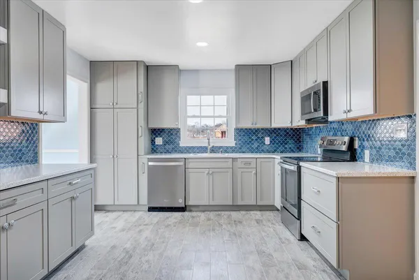 a kitchen with granite countertop white cabinets white stainless steel appliances and sink