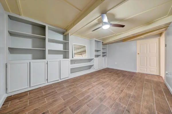 en empty room with ceiling fan and window