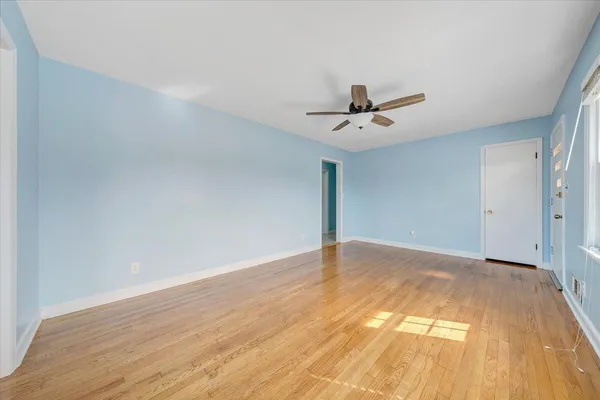 a view of a big room with wooden floor and a ceiling fan