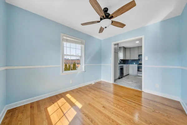 a view of empty room with wooden floor and window