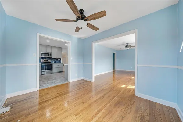 a view of a kitchen with wooden floor and a ceiling fan