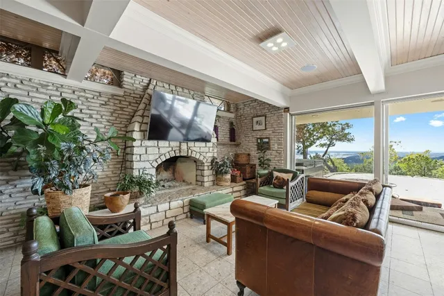 a living room with furniture a fireplace and a floor to ceiling window