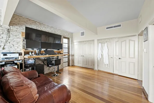 a large bedroom with a bed and wooden floor