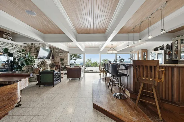 a view of a patio with table and chairs barbeque potted plants and large tree