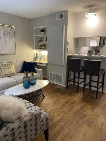 a living room with furniture and a wooden floor