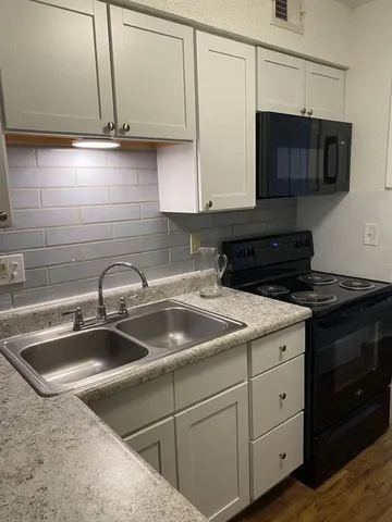 a kitchen with stainless steel appliances granite countertop a sink and a stove