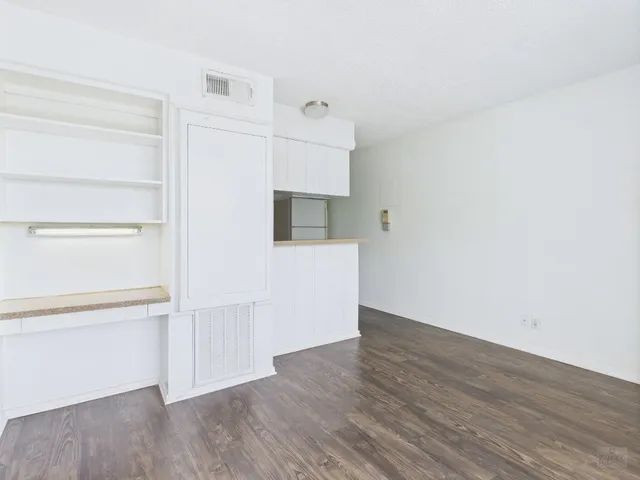 a view of a kitchen with wooden floor and electronic appliances