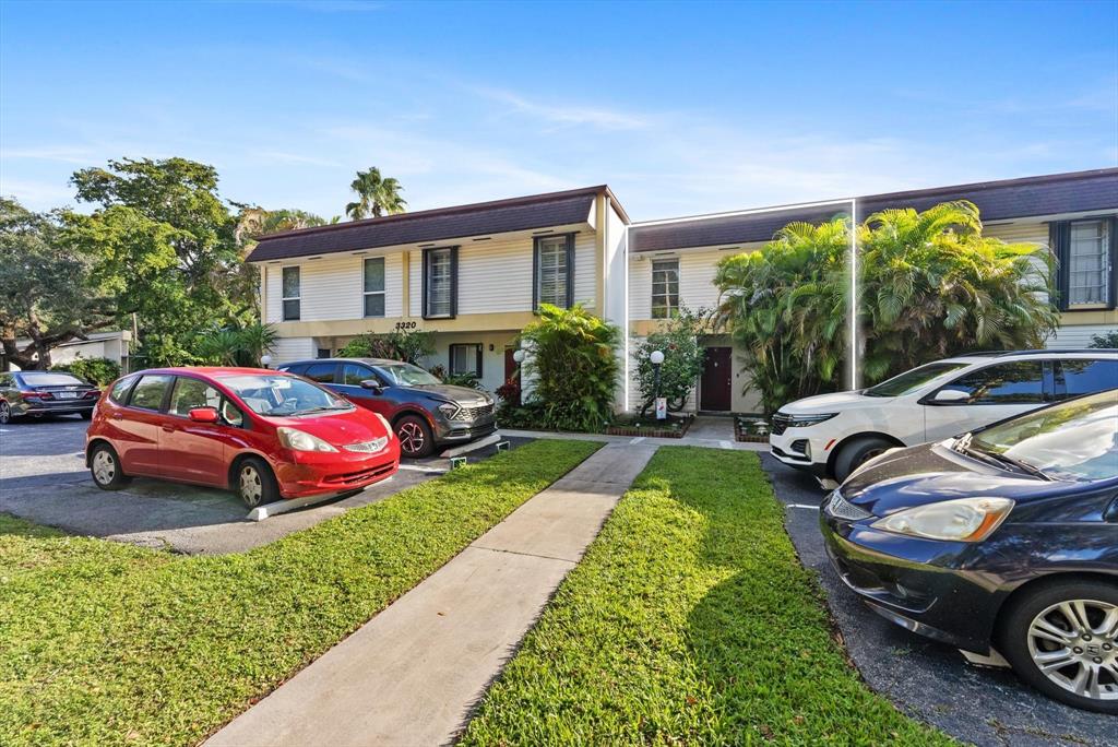 3320 Simms Street, Unit 11C Hollywood, FL 33021 - Photo 5 of 37 a front view of a house with a garden and parking space