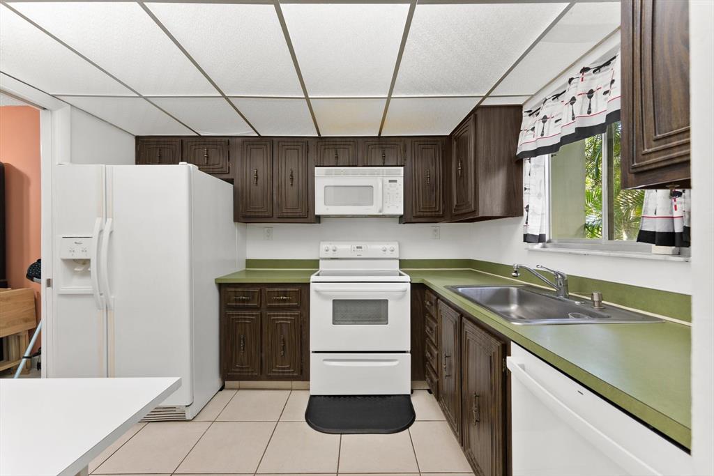 3320 Simms Street, Unit 11C Hollywood, FL 33021 - Photo 8 of 37 a kitchen with a stove sink and refrigerator