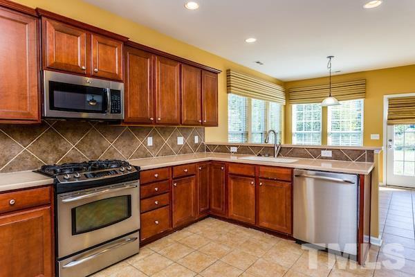 317 Euphoria Circle Cary, NC 27519 - Photo 4 of 22 a kitchen with stainless steel appliances granite countertop a stove microwave and sink