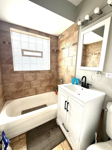 a bathroom with a bathtub sink and mirror