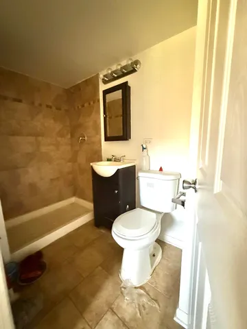 a bathroom with a toilet sink and mirror