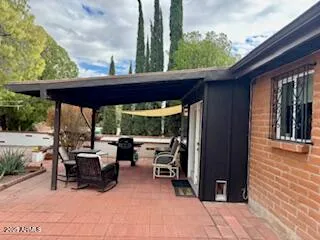 a backyard of a house with barbeque oven table and chairs