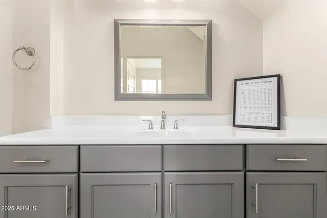 a bathroom with a sink vanity and mirror
