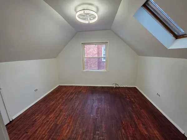 an empty room with a hardwood and a window
