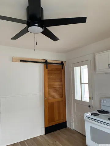 a view of empty room with window and ceiling fan