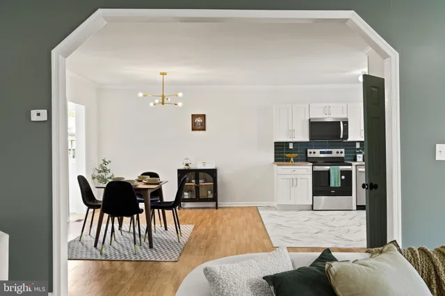 a living room with furniture and a dining table with kitchen view