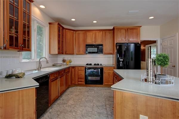 24 Battle Flagg Road Bedford, MA 01730 - Photo 15 of 30 a kitchen with stainless steel appliances granite countertop a refrigerator a sink dishwasher and wooden cabinets with a stove