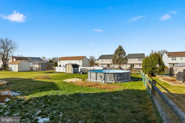 a view of a house with a big yard plants and large trees