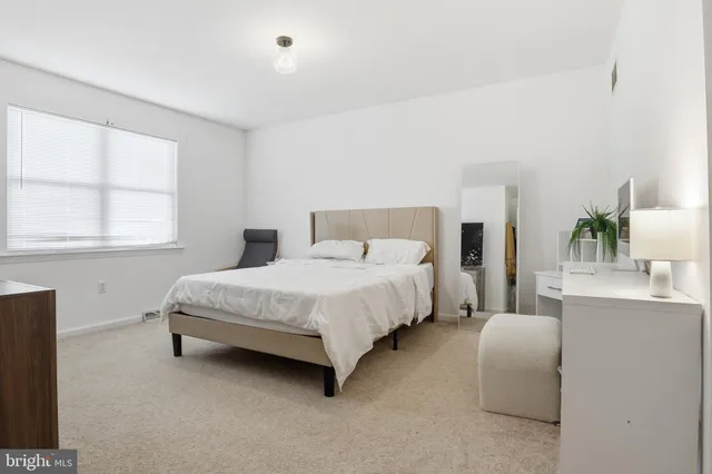 a bedroom with a bed lamp and window