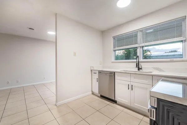 a kitchen with a sink cabinets and window