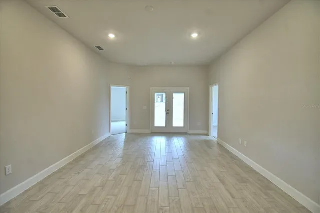 a view of empty room with wooden floor