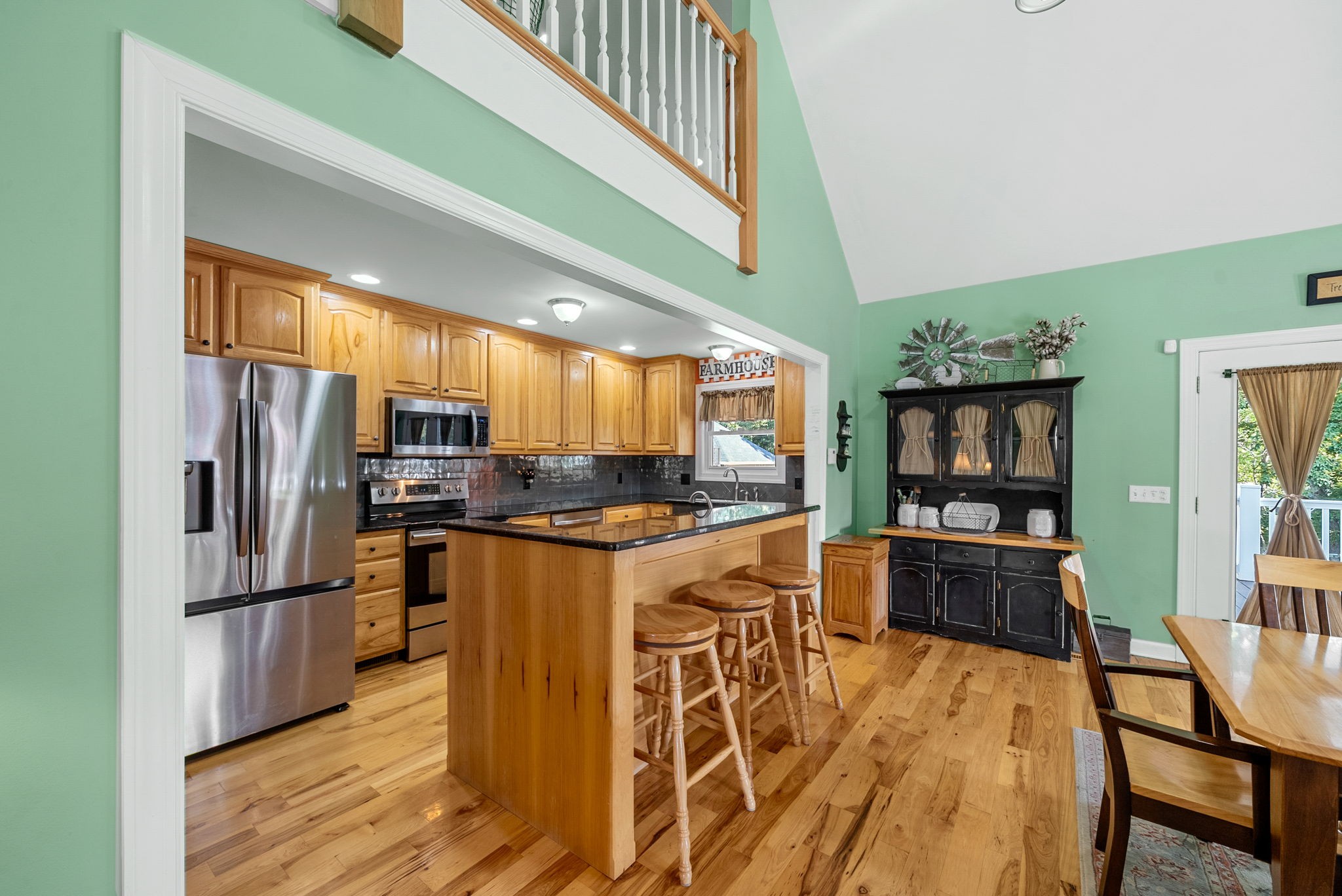 2834 Mosley Ferry Road Ashland City, TN 37015 - Photo 19 of 89 a kitchen with stainless steel appliances kitchen island granite countertop a refrigerator a stove a sink dishwasher and a dining table with wooden floor