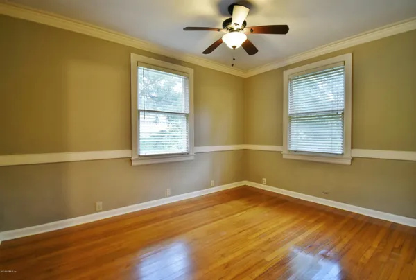 a view of a room with wooden floor and windows