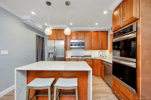 a kitchen with stainless steel appliances granite countertop a refrigerator a stove and a sink