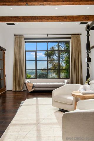 a bedroom with furniture and large windows