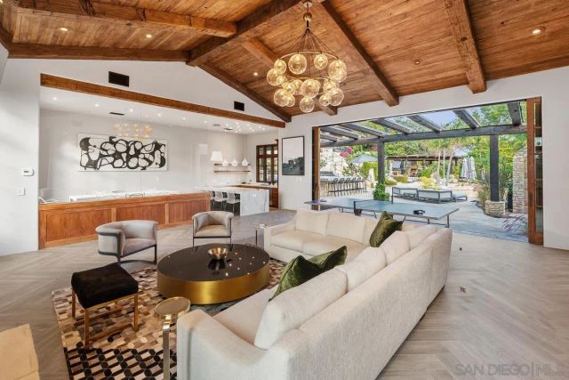 a living room with stainless steel appliances kitchen island granite countertop furniture and a large window