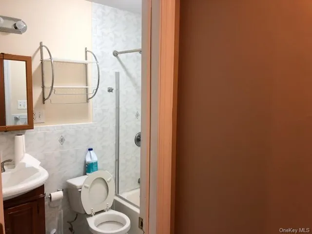 a bathroom with a granite countertop sink mirror and toilet