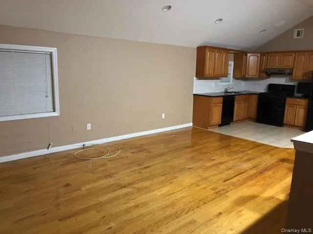 a view of kitchen with kitchen island microwave and window