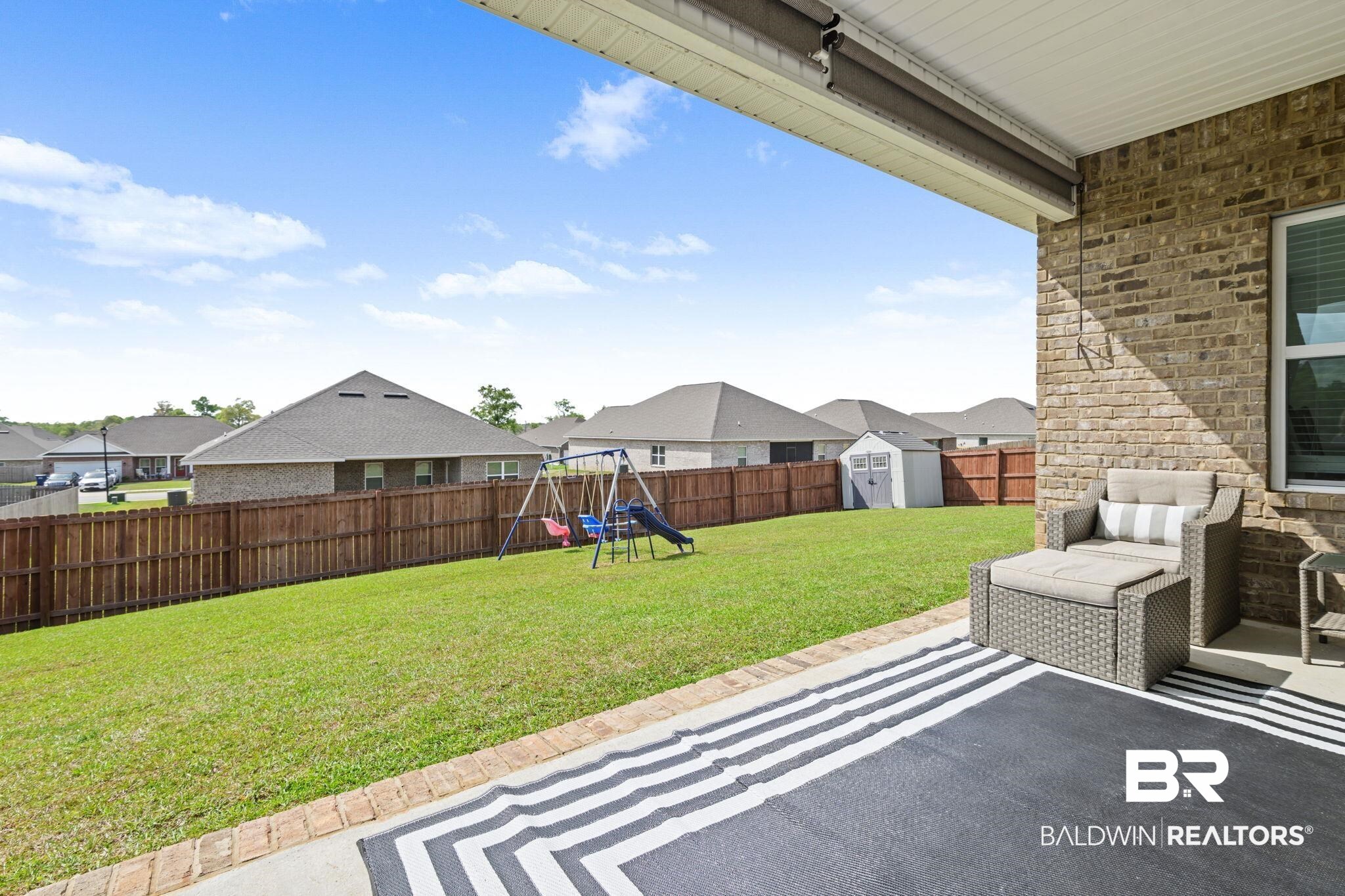 2183 Meadowview Loop Semmes, AL 36575 - Photo 10 of 58 Fenced backyard with a patio area, a storage unit, a playground, and a residential view