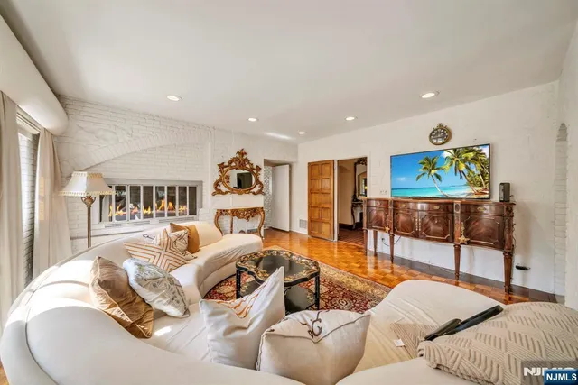 a living room with fireplace furniture and a potted plant