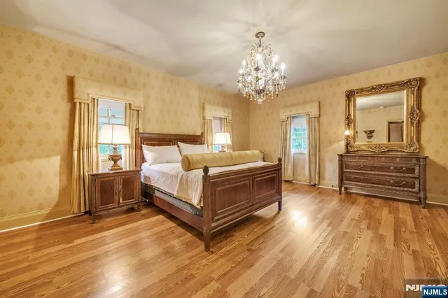 a spacious bedroom with a bed and a chandelier