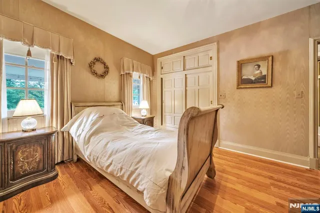 a bedroom with bed and wooden floor