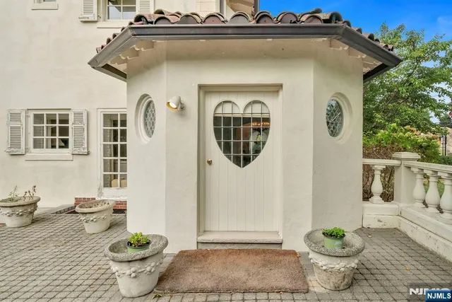 a front view of a house with a yard and potted plants