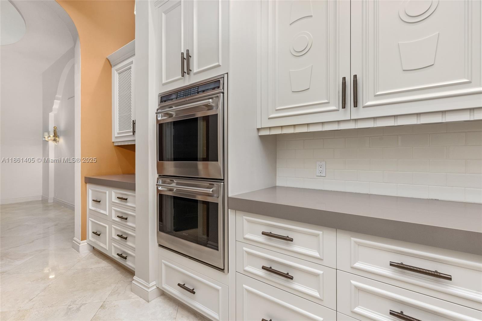 1504 Island Boulevard Aventura, FL 33160 - Photo 12 of 39 a kitchen with white cabinets and stainless steel appliances