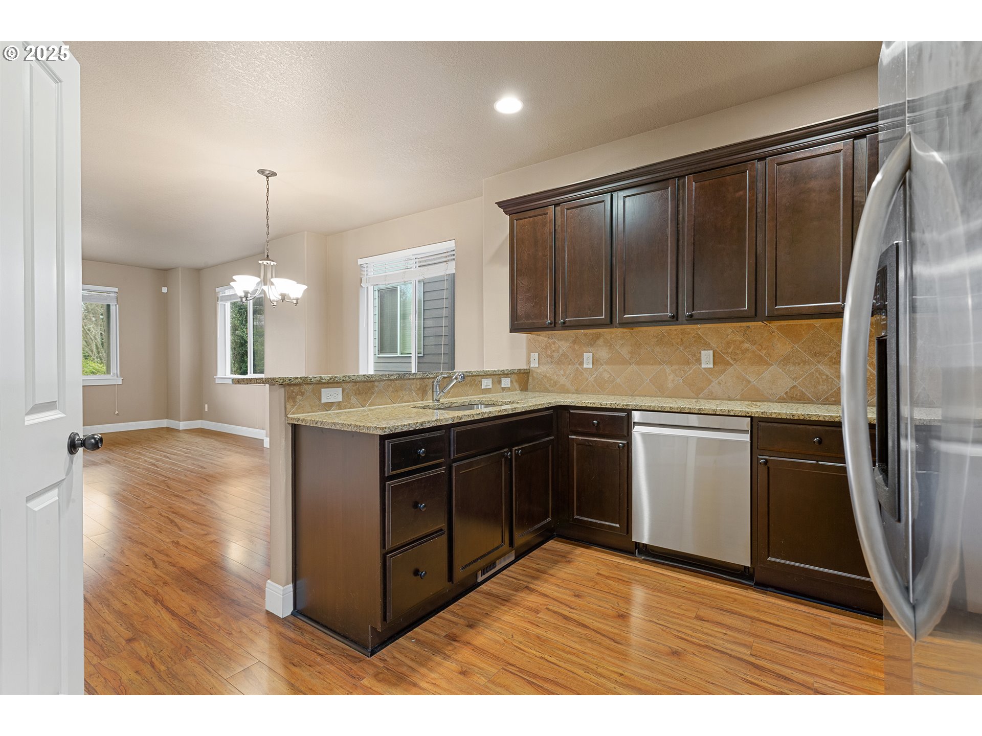 9622 Southwest Everett Terrace Tigard, OR 97223 - Photo 7 of 43 a kitchen with kitchen island granite countertop a sink refrigerator and microwave