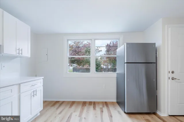 a view of a kitchen with wooden floor and electronic appliances