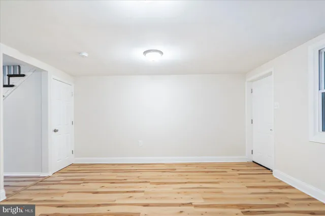 a view of room with wooden floor and white walls