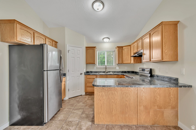 1118 North Ridge Court Spanish Fork, UT 84660 - Photo 10 of 32 Kitchen featuring stainless steel appliances, a peninsula, dark countertops, and vaulted ceiling